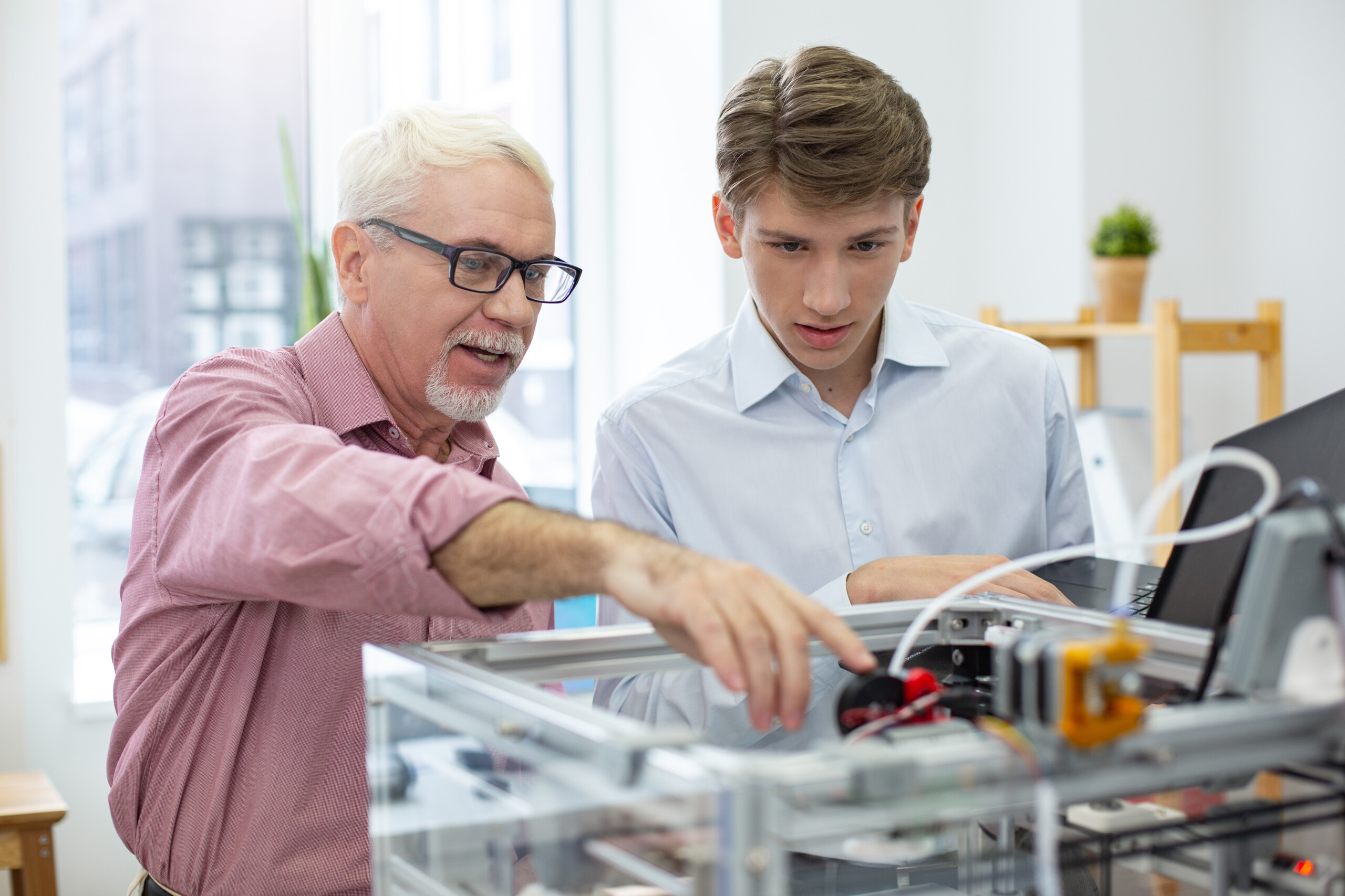 Experienced senior engineer instructing intern about 3D printers Workforce Development Program